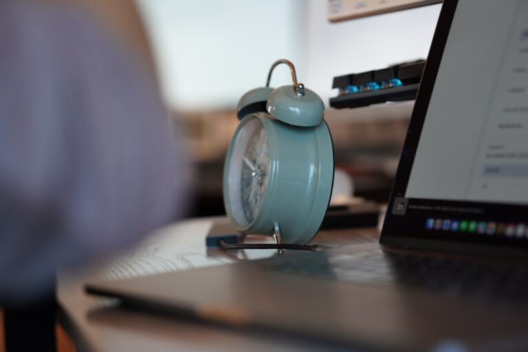 an alarm clock sitting on top of a laptop computer